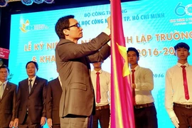 Phó Thủ tướng Vũ Đức Đam gắn Huân chương Độc lập Hạng Ba lên cờ truyền thống của Trường Đại học Công nghiệp Thành phố Hồ Chí Minh. (Ảnh: Thế Anh/TTXVN)
