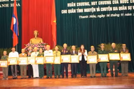 Các cán bộ chuyên gia, quân tình nguyện được trao tặng Huân, Huy chương của Nhà nước Lào. (Ảnh: Khiếu Tư/TTXVN)