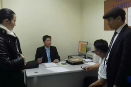 Đại diện Nga và Việt Nam làm thủ tục bàn giao đối tượng Nguyễn Xuân Đại về nước. (Ảnh: Dương Trí/Vietnam+)
