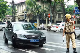 Cảnh sát giao thông ra hiệu lệnh dừng xe biển xanh trên phố Trần Phú, Hà Nội. (Ảnh: Doãn Tấn/TTXVN)