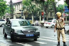 Cảnh sát giao thông ra hiệu lệnh dừng xe biển xanh trên phố Trần Phú, Hà Nội. (Ảnh: Doãn Tấn/TTXVN)