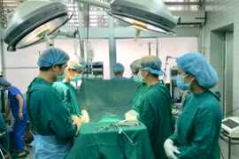 Các bác sỹ cúi đầu mặc niệm người hiến tạng. (Ảnh: TTXVN phát)