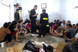 Các đối tượng đánh bạc bị bắt giữ. (Ảnh: Nguyễn Lân/Vietnam+)