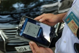 Nhân viên trông giữ xe tại các bãi đỗ đều được trang bị thiết bị quản lý và các máy in hóa đơn lưu động để phục vụ khách hàng một cách tốt nhất và nhanh nhất. (Ảnh: Huy Hùng/TTXVN)