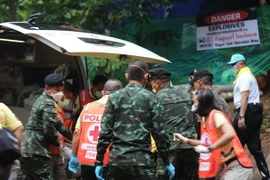 Binh sỹ và nhân viên y tế Thái Lan chuyển các thành viên đội bóng sau khi được cứu khỏi hang Tham Luang lên xe cứu thương ngày 8/7. Ảnh: (Nguồn: AFP/TTXVN)