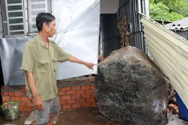Tảng đá nặng khoảng hơn 3 tấn lăn vào nhà ông Huỳnh Thanh Phong. (Ảnh: Lê Sen/TTXVN)