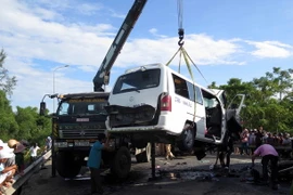 Xe cứu hộ cẩu chiếc xe ô tô khách bị nạn mang biển số 75B-00052 ra khỏi hiện trường. (Ảnh: Đỗ Trưởng/TTXVN)