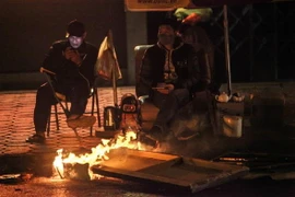 Người dân lao động đốt lửa, chống lại cái lạnh trong đêm. (Ảnh: Minh Hoàng/TTXVN phát)