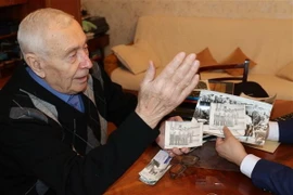 Trung tướng Porfiry Ivashko say sưa nói về từng bức ảnh. (Ảnh: Hồng Quân/TTXVN)