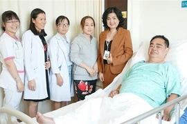 Đội ngũ nhân viên y tế và bệnh nhân sau can thiệp. (Ảnh: TTXVN phát)
