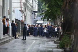 Nhân viên khách sạn Metropole dời ra bên ngoài khu vực cổng phụ trên phố Lý Thái Tổ theo yêu cầu của đoàn Triều Tiên. (Ảnh: Minh Quyết/TTXVN)