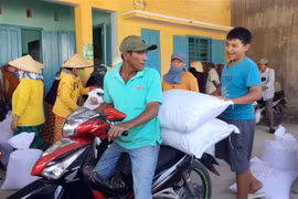 Người dân ở xã Phước Nam, huyện Thuận Nam, Ninh Thuận chở gạo cấp phát cứu đói do Chính phủ hỗ trợ. (Ảnh: Công Thử/TTXVN)