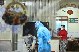 Nhân viên y tế đến theo dõi, kiểm tra sức khỏe cho 7 bệnh nhân F0 trong 1 gia đình tại nhà ở xã Tam Hiệp, huyện Thanh Trì, Hà Nội. (Ảnh: Minh Quyết/TTXVN)