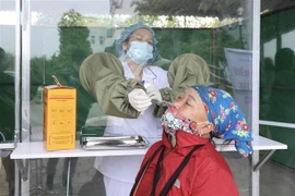 Nhân viên y tế lấy mẫu xét nghiệm COVID-19 cho người nhà vào chăm bệnh nhân tại bệnh viện đa khoa Yên Bái, đảm bảo an toàn trong công tác phòng, chống dịch. (Ảnh: Minh Quyết/TTXVN)