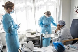Nhân viên y tế điều trị cho bệnh nhân COVID-19 tại bệnh viện ở Copenhagen, Đan Mạch. (Ảnh: AFP/TTXVN)