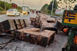 Hiện trường các khối bêtông rơi từ xe đầu kéo xuống đường và đè chết người. (Ảnh: TTXVN phát)