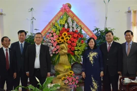 Trưởng Ban Dân vận Trung ương Bùi Thị Minh Hoài tặng hoa, quà chúc mừng Giáng sinh tới Giám mục Vũ Đình Hiệu cùng toàn thể các chức sắc, tu sỹ tại Giáo phận Bùi Chu. (Ảnh: Công Luật/TTXVN)