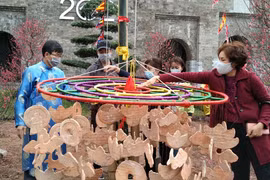 Nghi lễ treo khánh đất nung lên cây nêu mong một năm mới sung túc, xua đuổi những điều không may. (Ảnh: Minh Thu/Vietnam+)