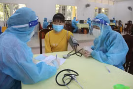 Khám sàng lọc trước khi tiêm vaccine tại điểm tiêm trường Đại học Trà Vinh. (Ảnh: Thanh Hòa/TTXVN)