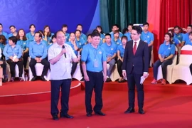 Thủ tướng trao đổi, giải đáp những ý kiến của công nhân lao động. (Ảnh: Hồng Kiều/Vietnam+) 