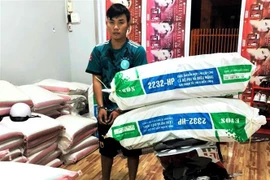 Đối tượng Lâm Văn Khang vận chuyển 2 bao tải lớn chứa 1.000 bao thuốc lá ngoại nhập lậu, bị Công an bắt quả tang. (Ảnh: TTXVN phát)