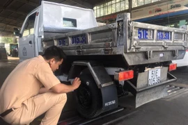 Cán bộ Cảnh sát giao thông làm nhiệm vụ hỗ trợ đăng kiểm tại Trung tâm đăng kiểm 50-02S. (Ảnh: Linh Sơn/TTXVN)