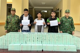 Các đối tượng Phùng Văn Quốc, Lương Văn Cường và Lý Văn Lực cùng tang vật. (Ảnh: TTXVN phát)