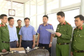 Cơ quan điều tra đọc lệnh khám xét tại nơi làm việc của Nguyễn Văn Chiến. (Ảnh: TTXVN phát)