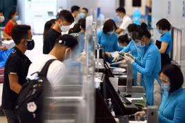 Hành khách làm thủ tục lên máy bay tại quầy của hãng hàng không Vietnam Airline. (Ảnh: Huy Hùng/TTXVN)
