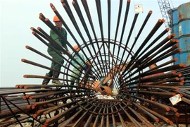 Các nhà thầu huy động tối đa phương tiện máy móc và nhân công để thi công cầu qua cửa biển Thuận An, thành phố Huế, tỉnh Thừa Thiên-Huế. (Ảnh: Đỗ Trưởng/TTXVN)