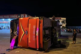 Xe khách bị lật ngang giữa đường, hư hỏng nhiều vị trí. (Ảnh: TTXVN phát)