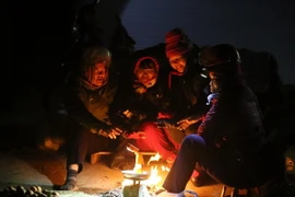 Những tiểu thương bán hàng tại chợ Mường Thanh đốt lửa sưởi ấm. (Ảnh: Phan Tuấn Anh/TTXVN)