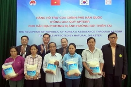 Đại diện lãnh đạo Bộ Nông nghiệp và Phát triển Nông thôn Việt Nam và Bộ Nông nghiệp, lương thực và nông thôn Hàn Quốc trao tặng gạo cho người dân vùng bị thiên tai của huyện Đại Lộc. (Ảnh : Đỗ Văn Trưởng/TTXVN)
