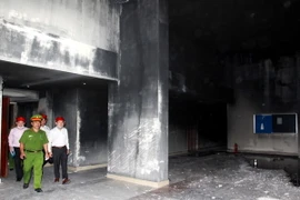 Lực lượng chức năng tiến hành điều tra nguyên nhân vụ cháy tại chung cư Carina Plaza. (Ảnh: Thanh Vũ/TTXVN)