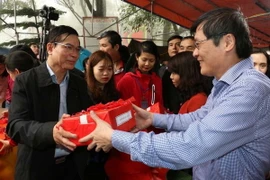 Phó Bí thư Thường trực tỉnh ủy Hải Dương Vũ Văn Sơn phát ngũ cốc cho các đại biểu và nhân dân. (Ảnh: Mạnh Minh/TTXVN)