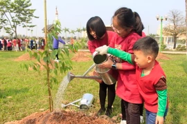 Các em nhỏ Việt Nam tham gia trồng cây hoa anh đào tại công viên Hòa Bình. (Ảnh: Nguyễn Văn Cảnh/TTXVN)