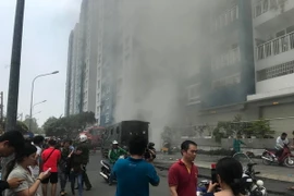 Khói bất ngờ bùng phát trở lại tại khu vực hầm để xe của chung cư Carina. (Ảnh: Thành Chung/TTXVN)