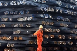 Công nhân vận chuyển thép cuộn tại một chợ thép ở Qingdao, tỉnh Sơn Đông, Trung Quốc. (Nguồn: AFP/TTXVN)