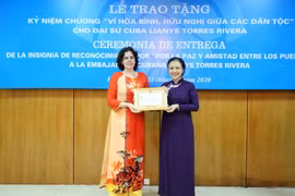 Chủ tịch Liên hiệp các tổ chức Hữu nghị Việt Nam Nguyễn Phương Nga trao Kỷ niệm chương cho Đại sứ Đặc mệnh toàn quyền Cuba tại Việt Nam Lianys Torres Rivera. (Ảnh: TTXVN)