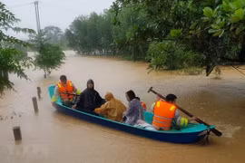 Di chuyển người dân ra khỏi khu vực ngập lũ tại huyện Cam Lộ, tỉnh Quảng Trị. (Ảnh: Thanh Thủy/TTXVN)