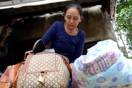 Người dân khẩn trương thu dọn đồ đạc, chuyển đến nơi an toàn để tránh bão số 9. (Ảnh: Quốc Dũng/TTXVN)