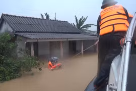 Bộ đội Biên phòng tỉnh Quảng Trị di dời những người dân bị mắc kẹt trong lũ đến nơi an toàn. (Ảnh: Hồ Cầu/TTXVN)