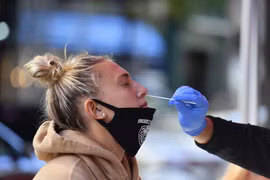Nhân viên y tế lấy mẫu xét nghiệm COVID-19 cho người dân tại New York, Mỹ. (Ảnh: AFP/TTXVN)