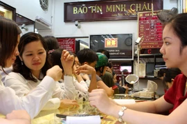 Khách hàng đang giao dịch vàng miếng. (Ảnh: TTXVN)