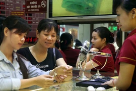 Khách hàng đang giao dịch vàng miếng tại hệ thống Bảo Tín Minh Châu (Ảnh: TTXVN)