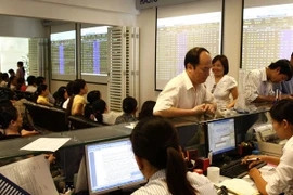 Nhà đầu tư đang giao dịch chứng khoán (Ảnh: TTXVN)