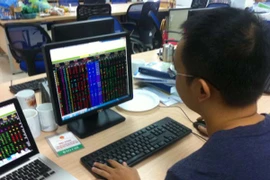 Nhà đầu tư đang theo dõi đặt lệnh giao dịch chứng khoán (Ảnh: PV/Vietnam+)