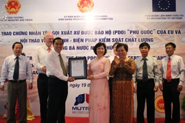 Lãnh đạo Bộ Công Thương trao giấy Chứng nhận tên gọi xuất xứ cho sản phẩm nước mắm Phú Quốc (Ảnh: TTXVN)