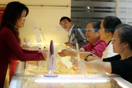 Khách hàng đang giao dịch vàng miếng miếng (Ảnh: TTXVN)