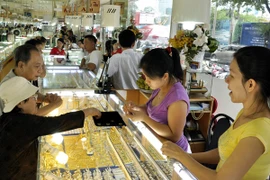 Khách hàng đang giao dịch vàng miếng (Ảnh: TTXVN)